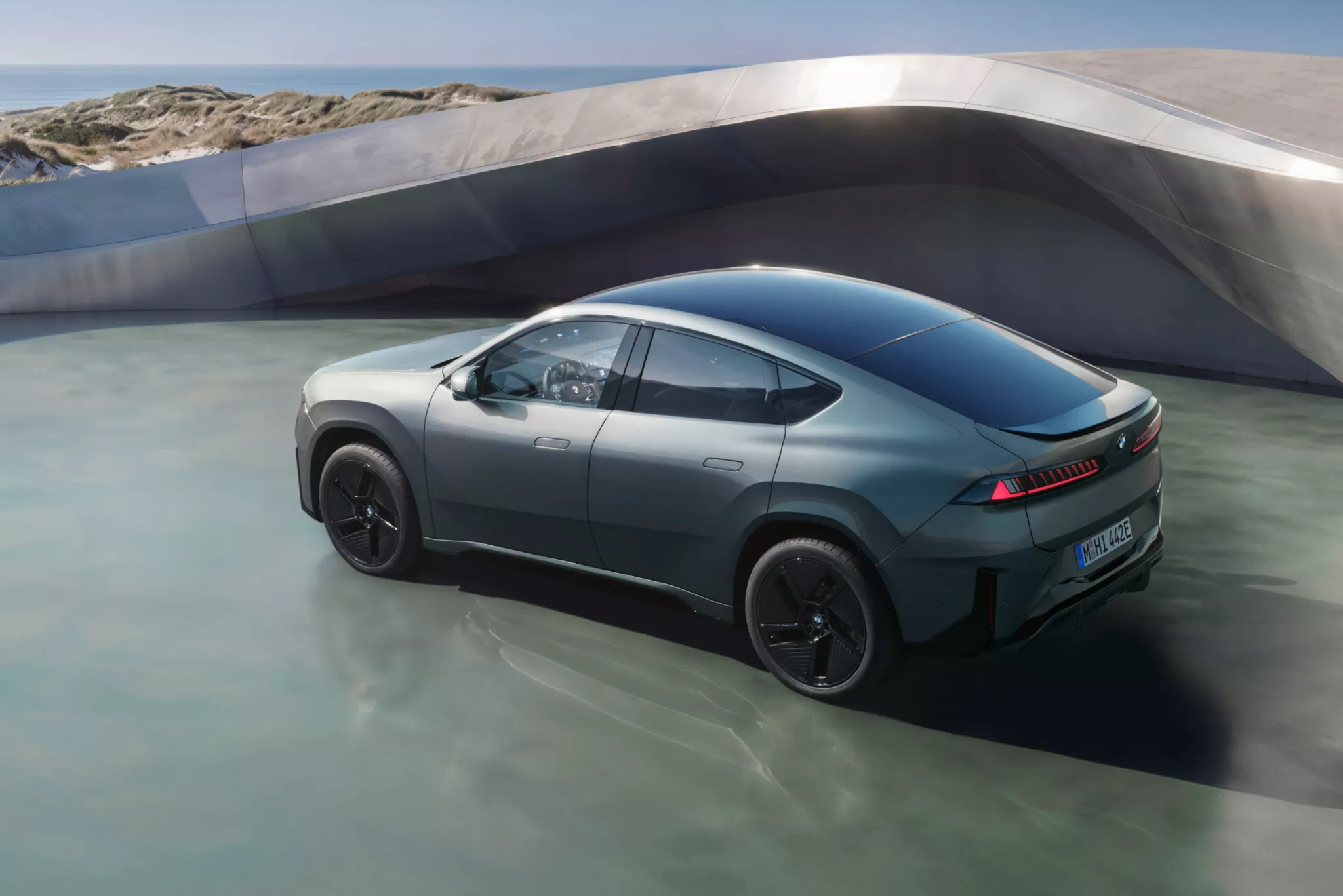 A természetben álló BMW iX4 50 xDrive, a járműoldal előzeteseként